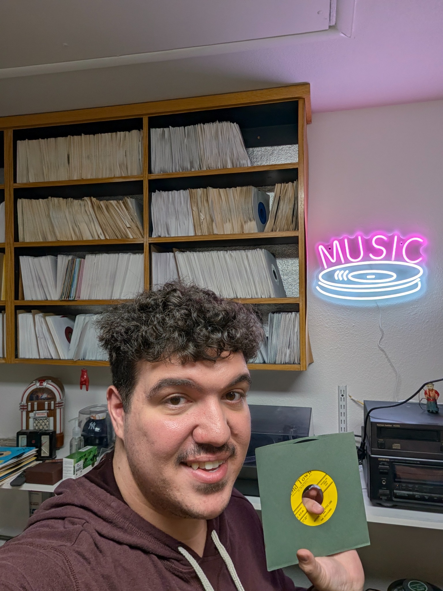 Vincent holding a record in front of shelves of vinyl
